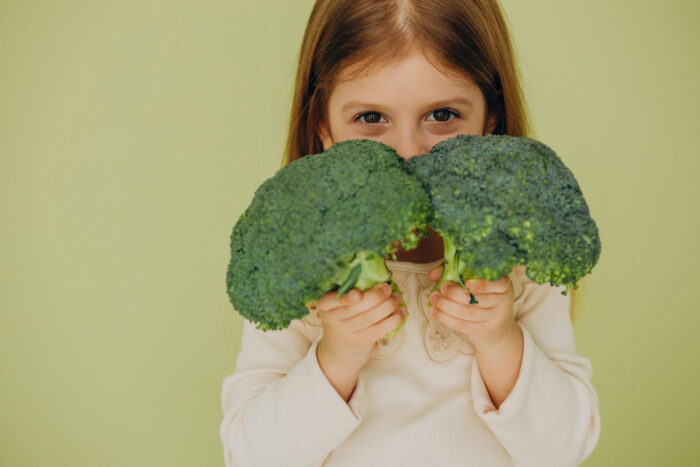 comer sano en vacaciones intur restauración colectiva niña con brócoli en las manos
